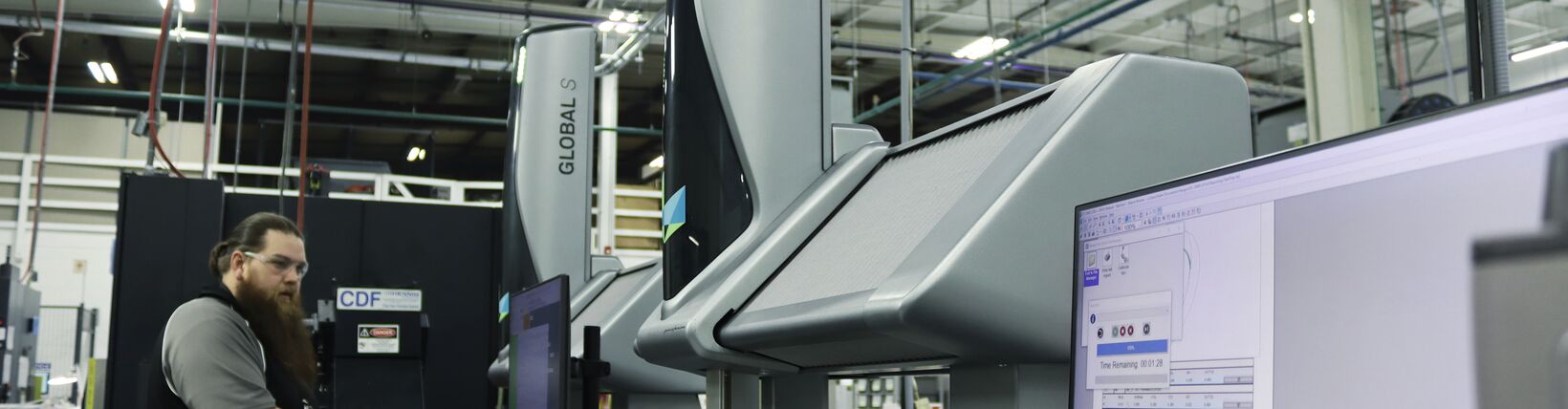 一名三坐标测量机操作员在两台全球S坐标测量机旁边使用一个移动箱