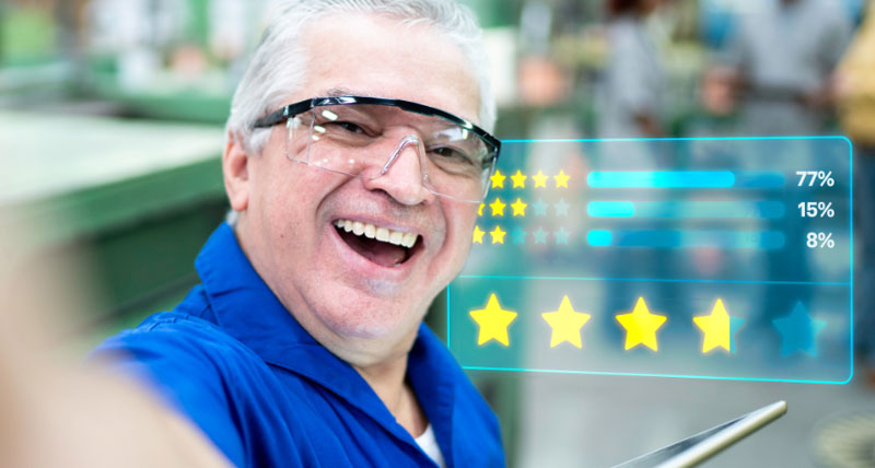 一名男子在车间环境中拿着桌子设备自拍。在后台有一个带有金星评级的网页。